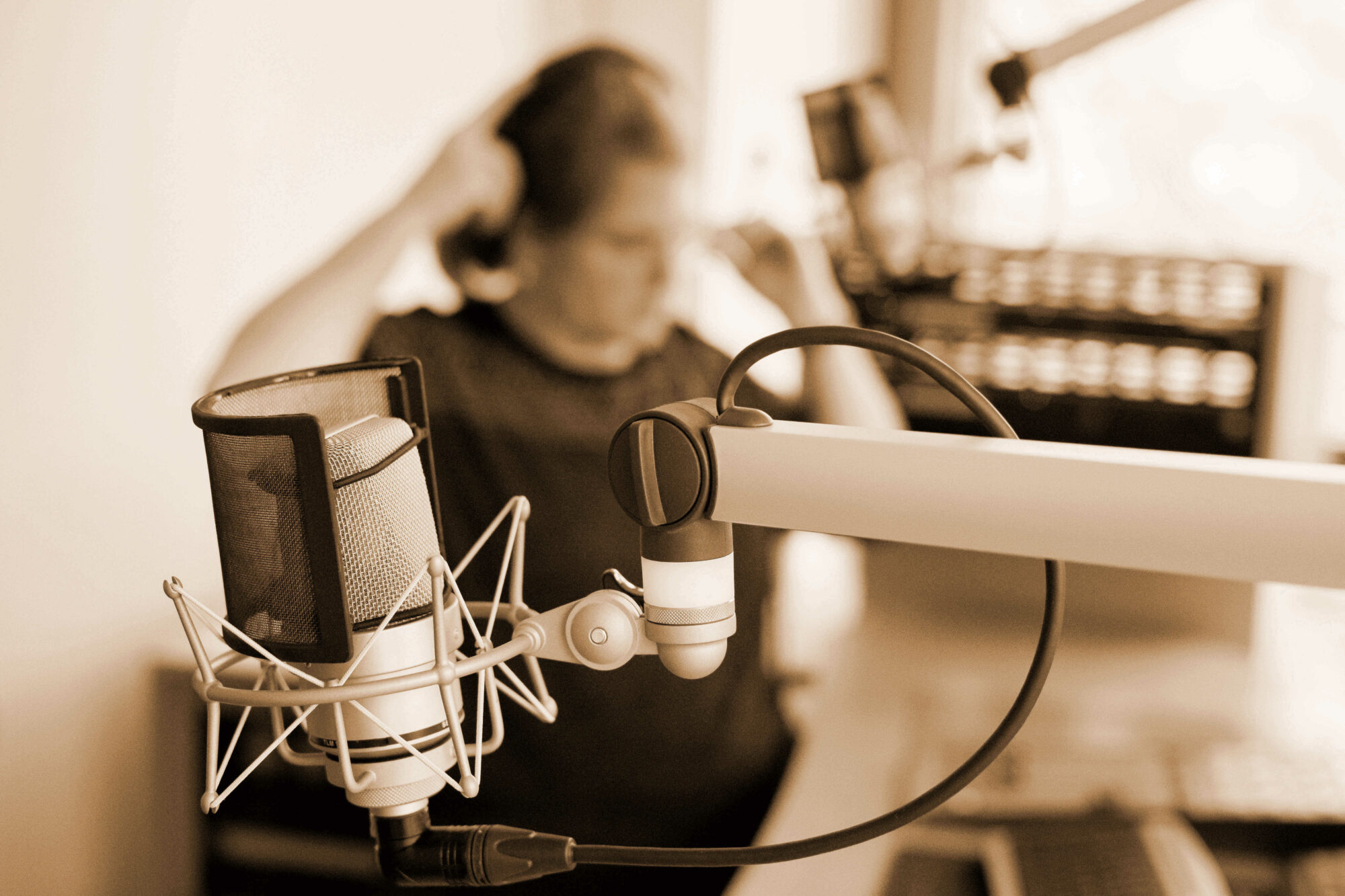 Sprecherin im Studio mit Aufnahmemikrofon
